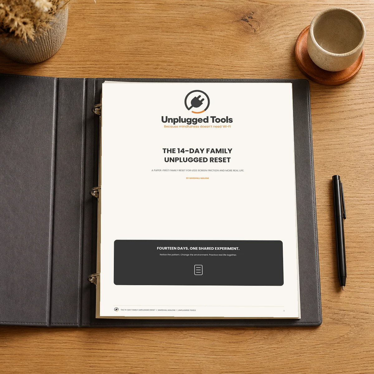 Printed 14-Day Family Unplugged Reset pages in an open charcoal three-ring binder on a wooden table.