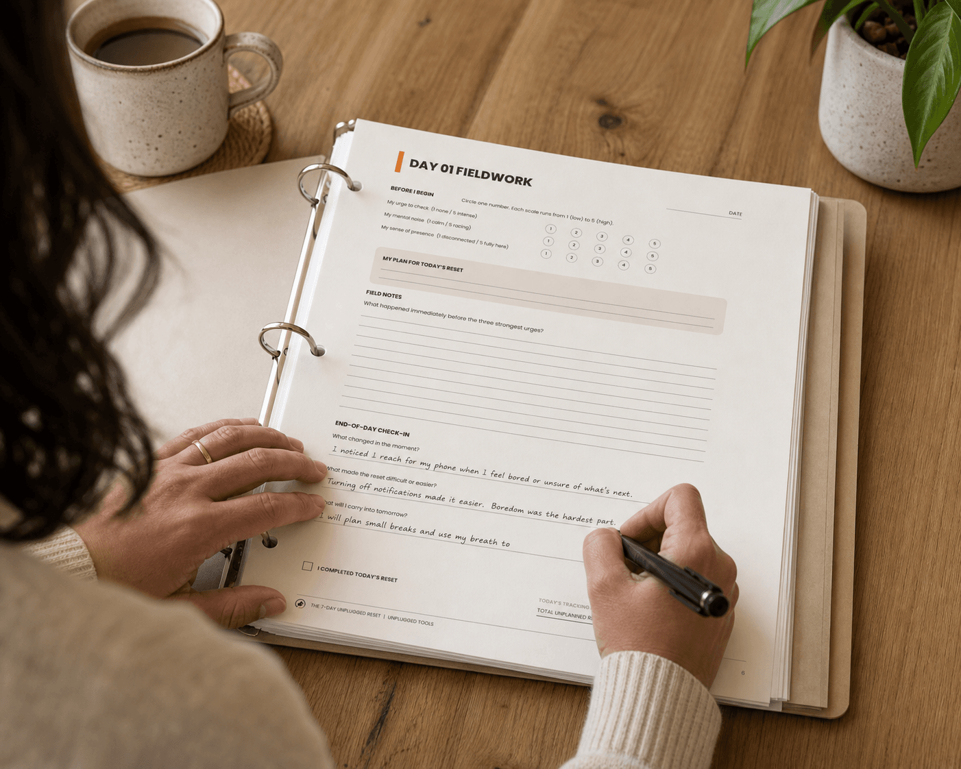 Person writing in the 7-Day Unplugged Reset printable workbook