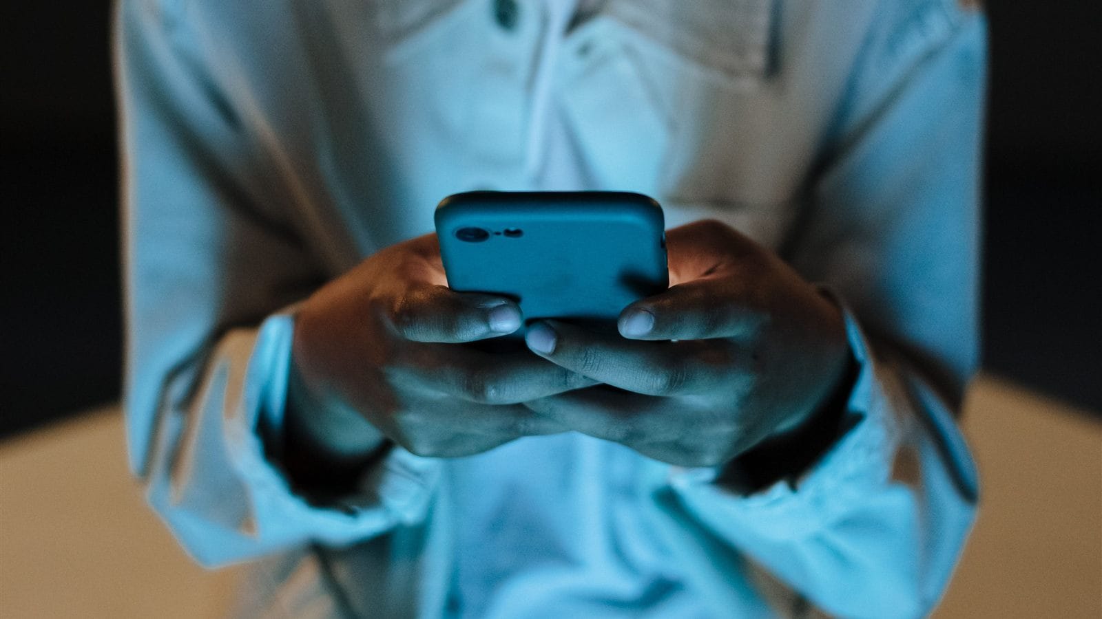 Person using a smartphone in a dark room at night
